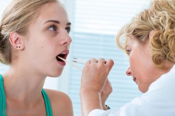 O médico examina a cavidade bucal para detectar a presenza de papilomas